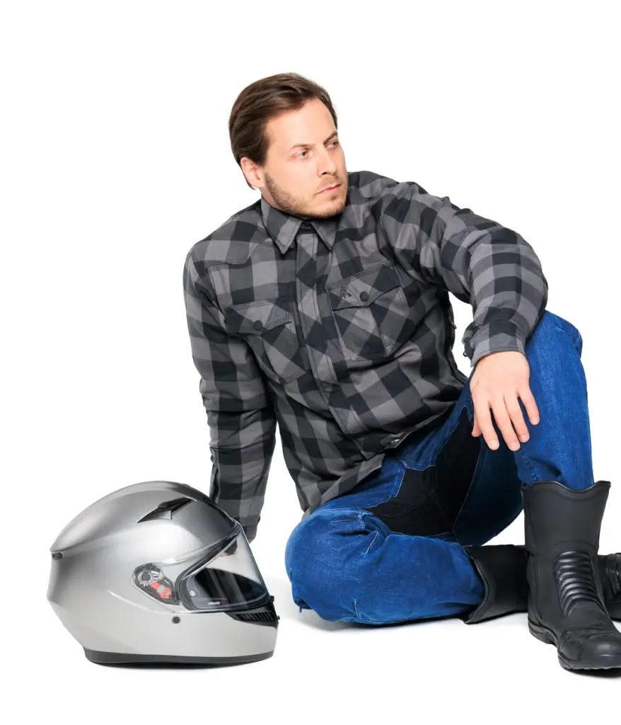 Alfa Thrust Casper Steel Grey – koszula motocyklowa, mężczyzna w szarej koszuli w kratę siedzący obok kasku.